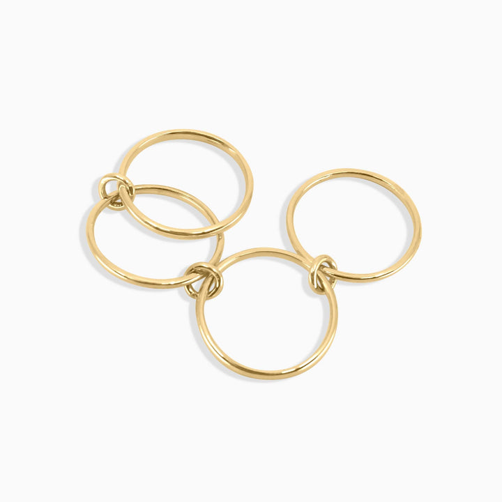 Gold ring with three interlocking loops on a white background
