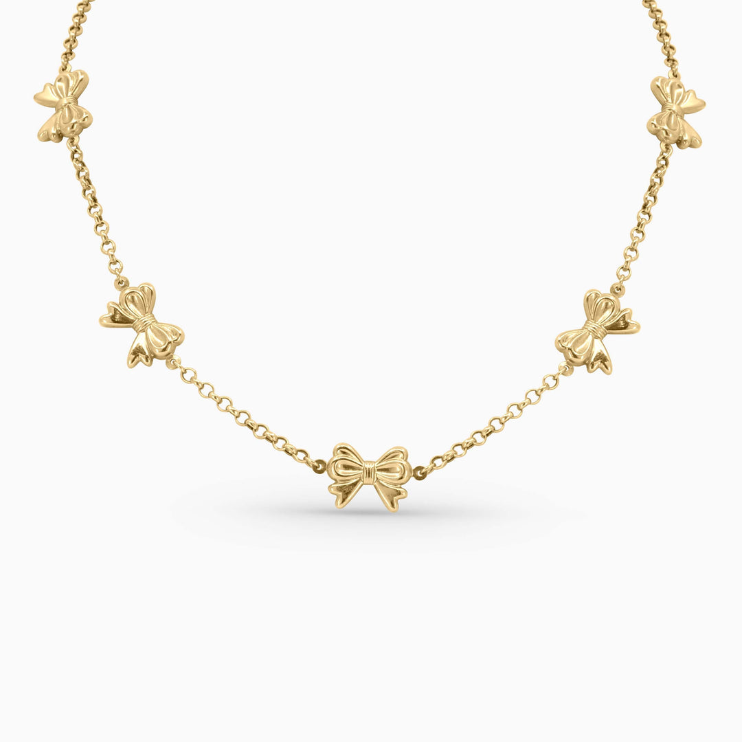 Gold necklace with bow-shaped pendants on a white background