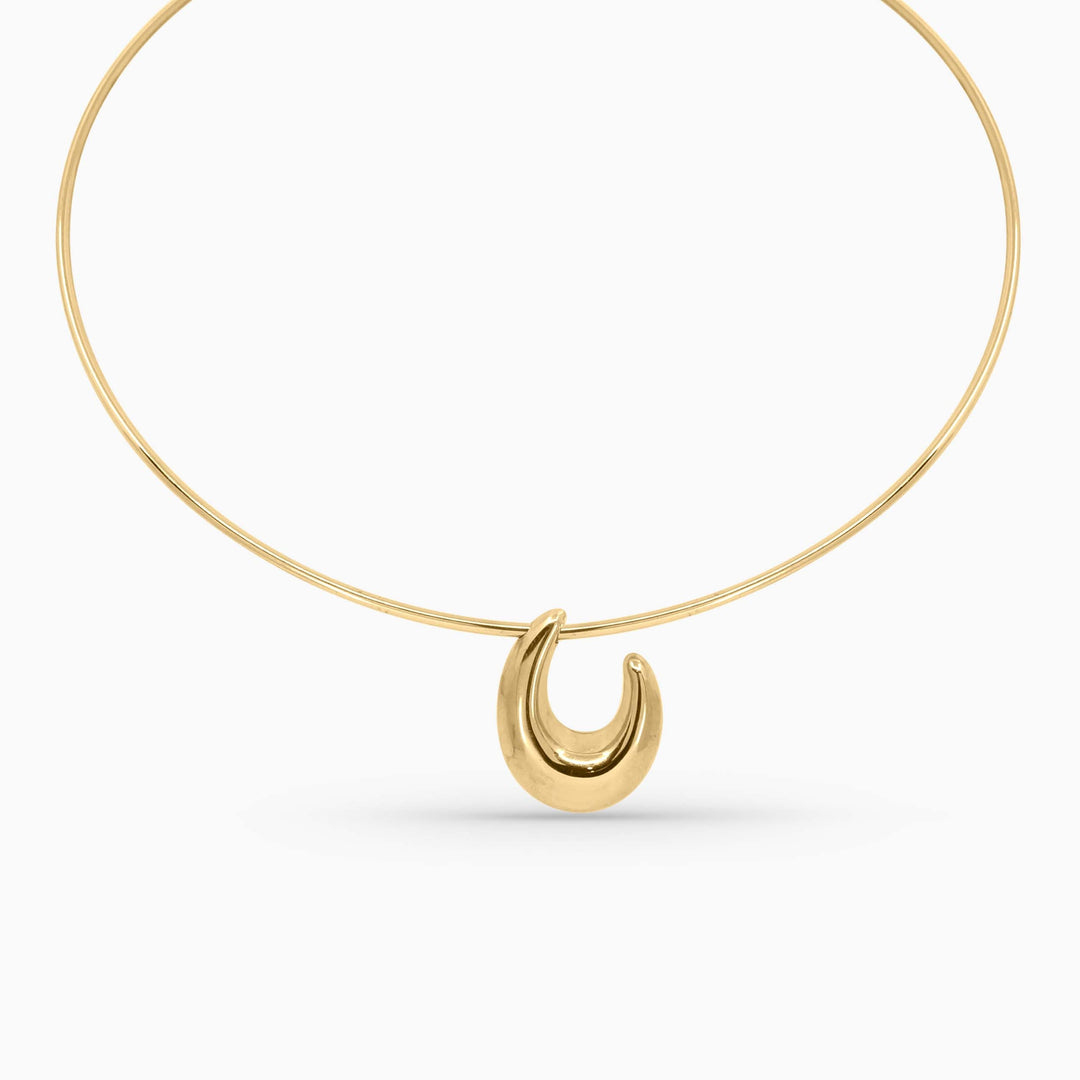 Gold necklace with a crescent moon pendant on a white background