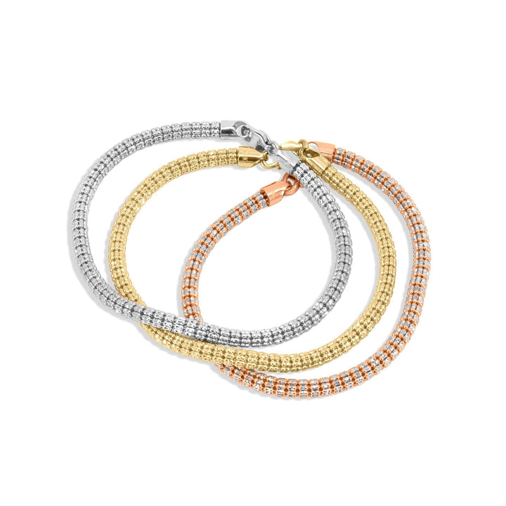 Three beaded bracelets in silver, gold, and rose gold on a white background