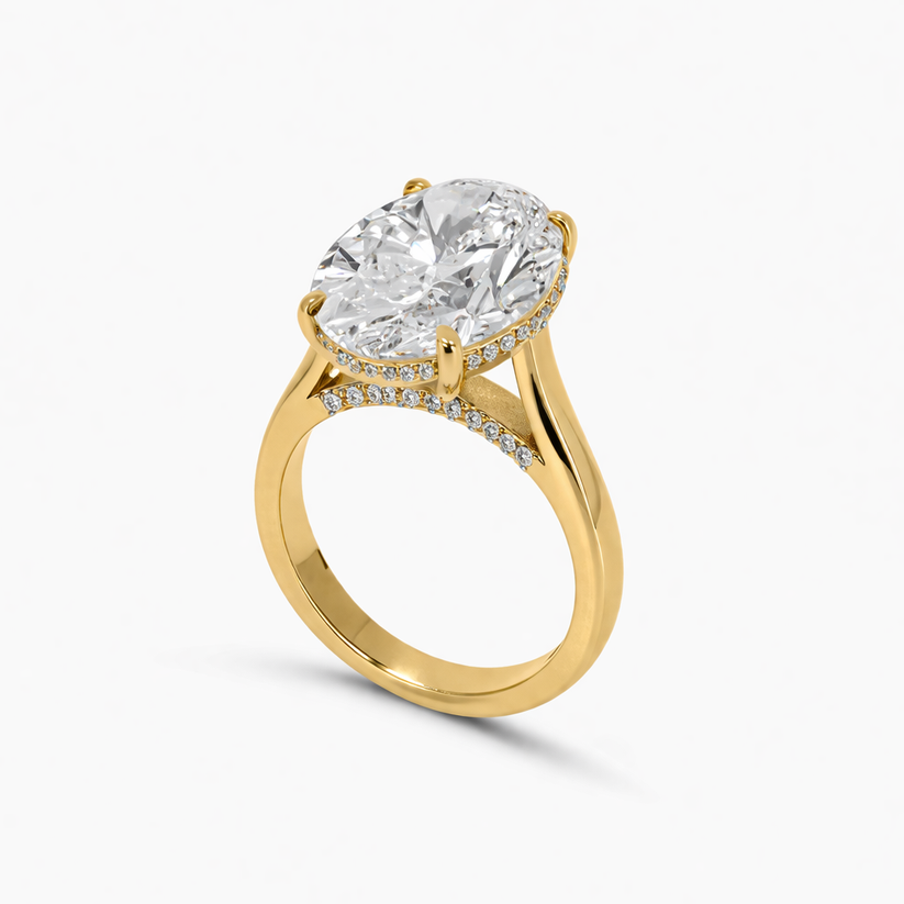 Gold ring with a large diamond and smaller diamonds on the band against a white background