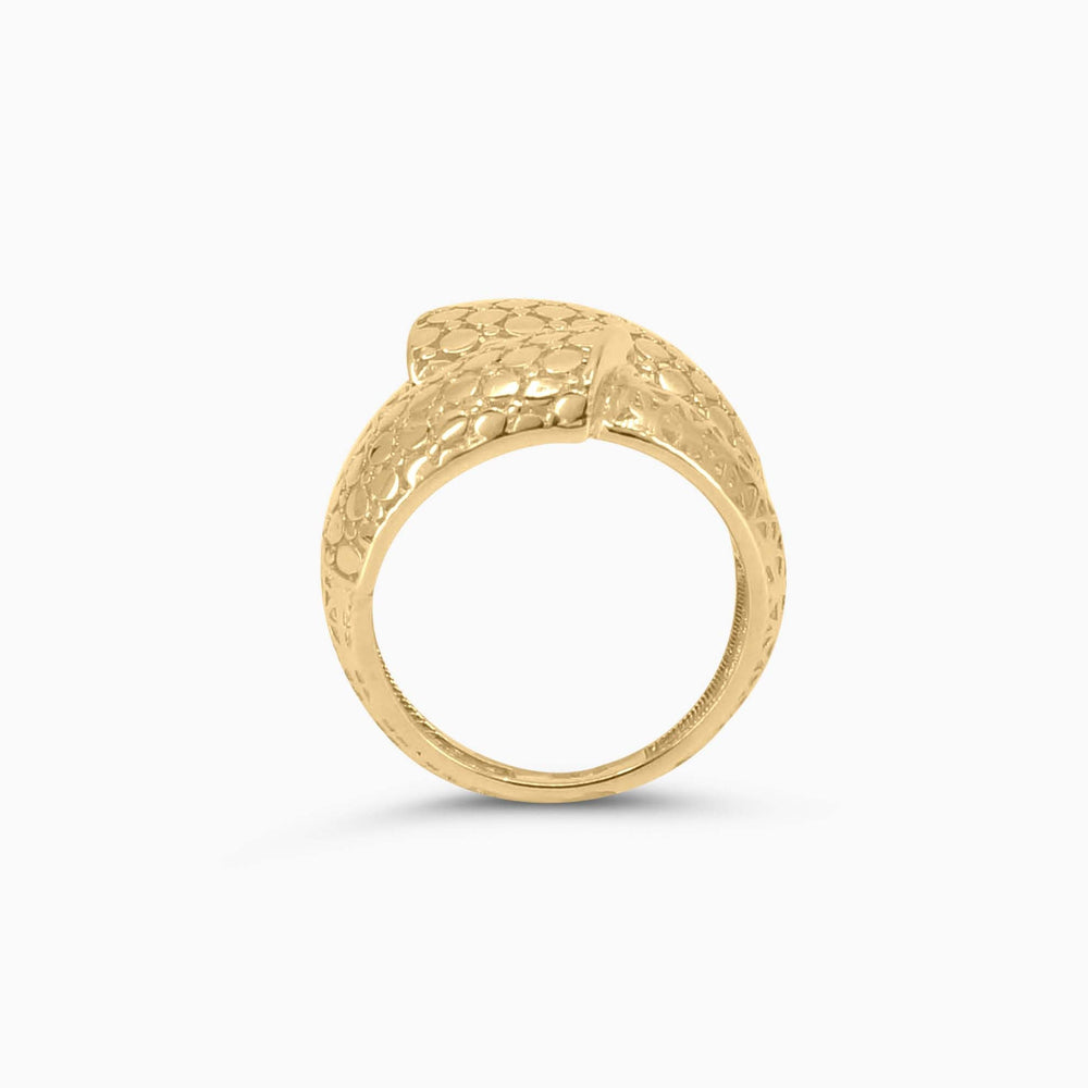 Gold ring with intricate design on a white background