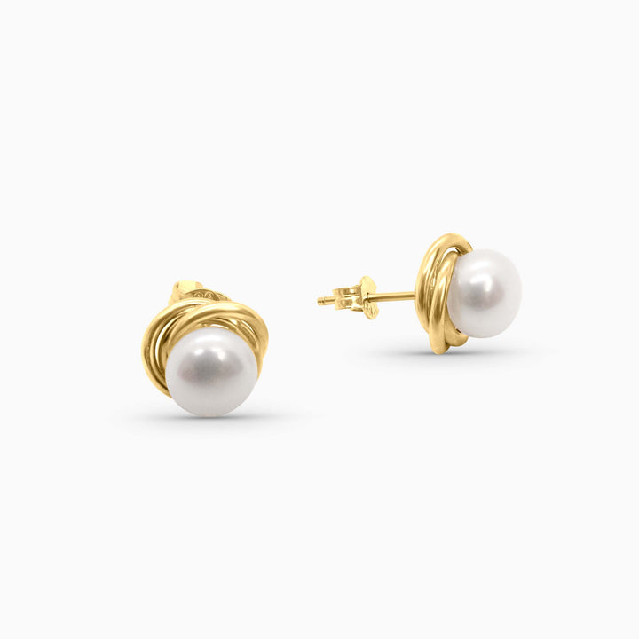 Pair of pearl earrings with gold settings on a white background
