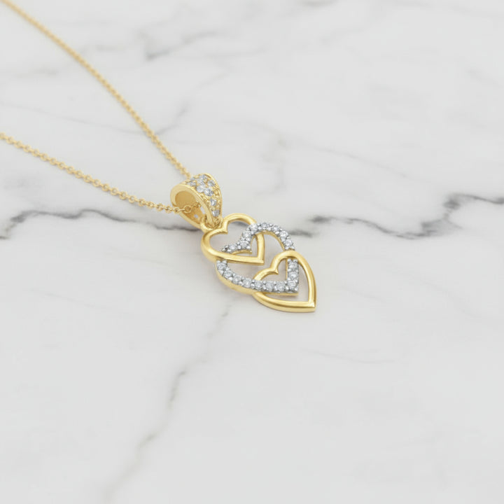 Gold pendant with heart design on a white background