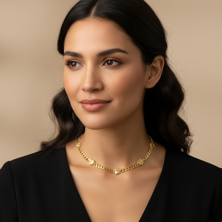 Woman wearing a gold necklace against a beige background