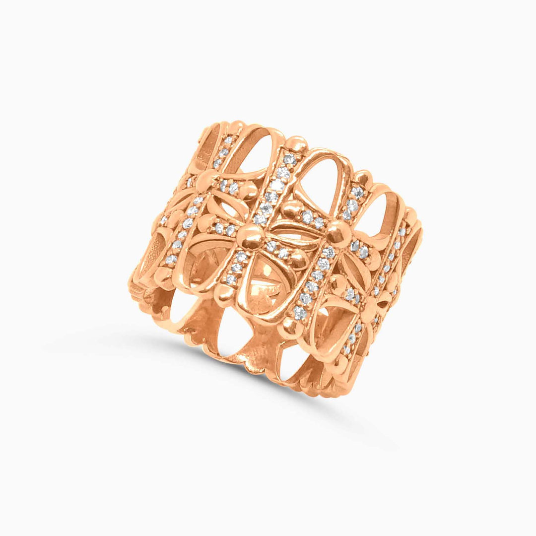 Rose gold ring with intricate design on a white background