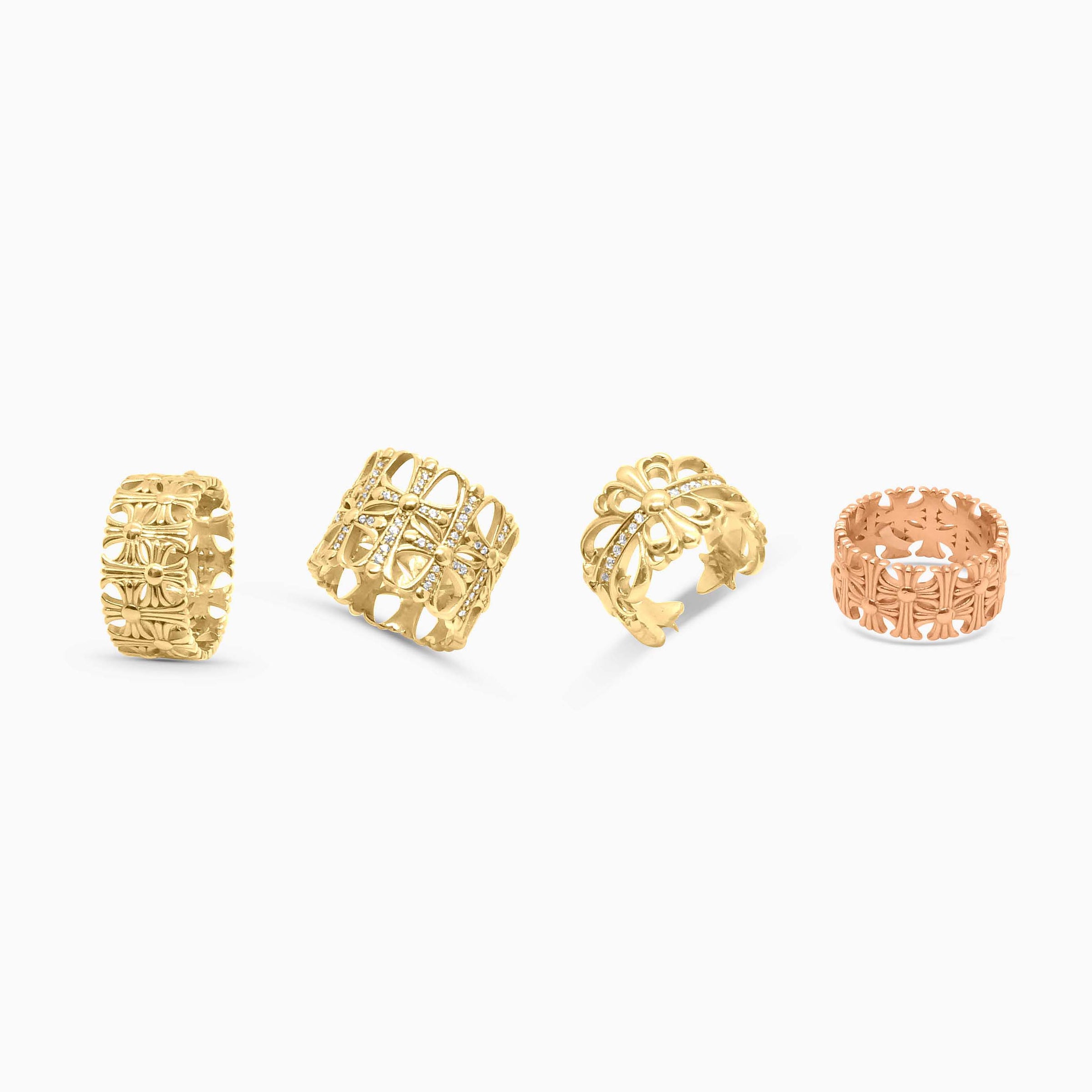 Four gold rings with intricate designs on a white background