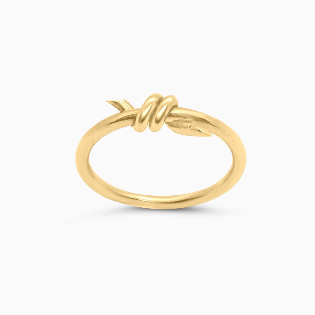 Gold ring with a knot design on a white background