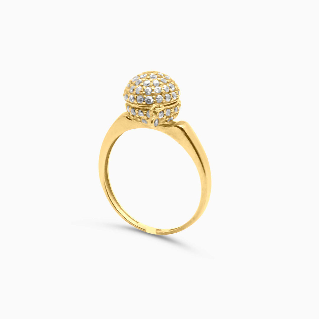 Gold ring with a diamond-encrusted ball on a white background
