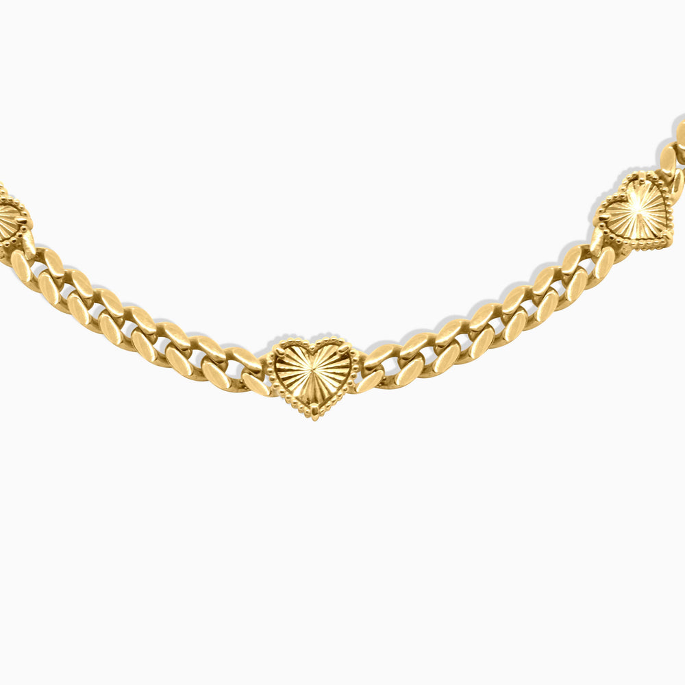 Gold chain necklace with heart-shaped links on a white background