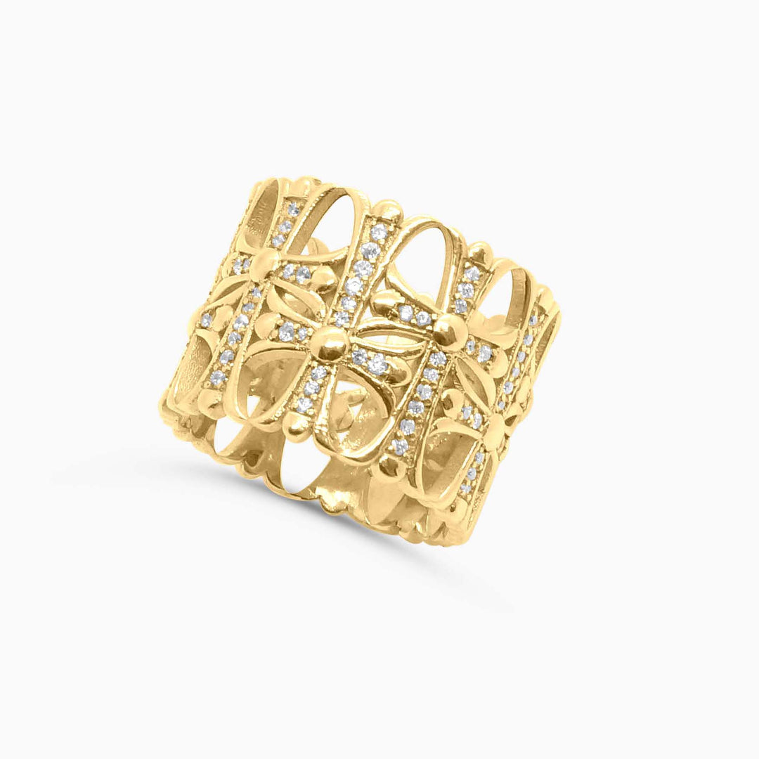 Gold ring with intricate design and small diamonds on a white background