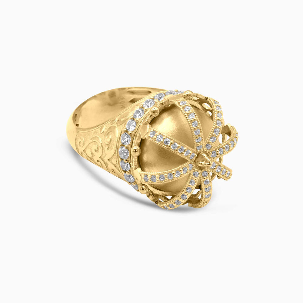 Gold ring with intricate design and embedded stones on a white background