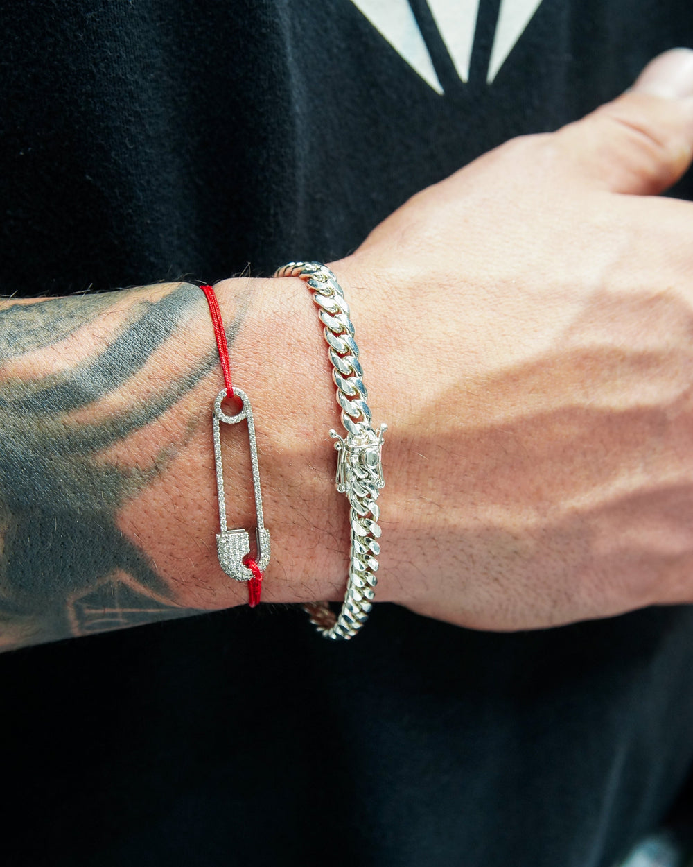 Close-up of a person's wrist with multiple bracelets on a black background