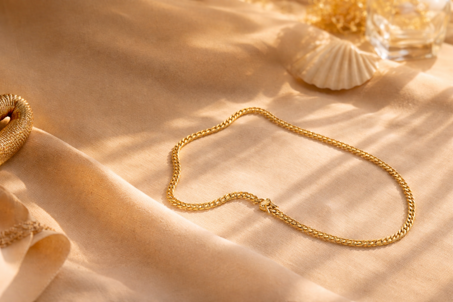 Gold chain necklace on a beige fabric background